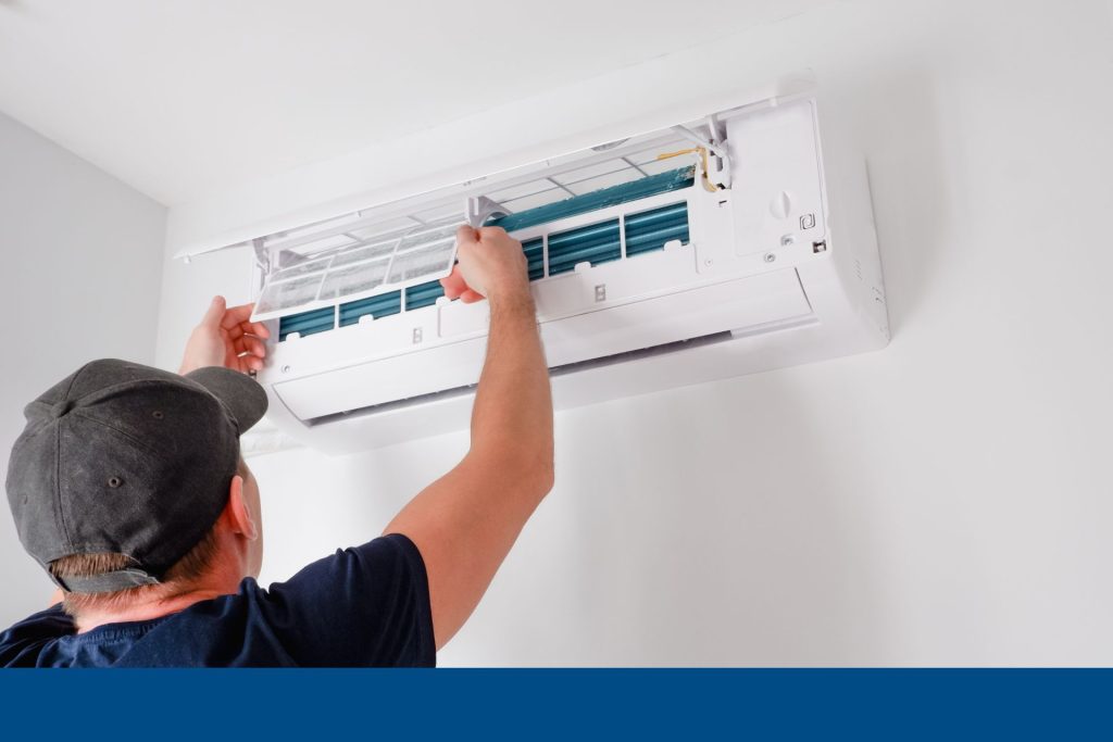 A person repairing an AC unit