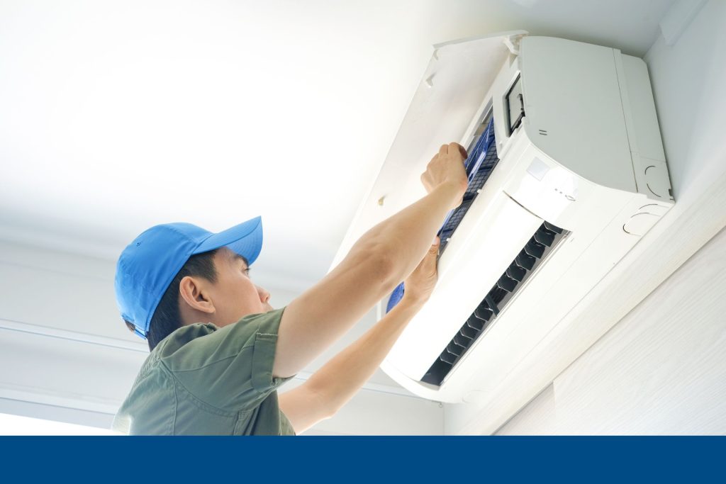 An HVAC technician working on an AC unit
