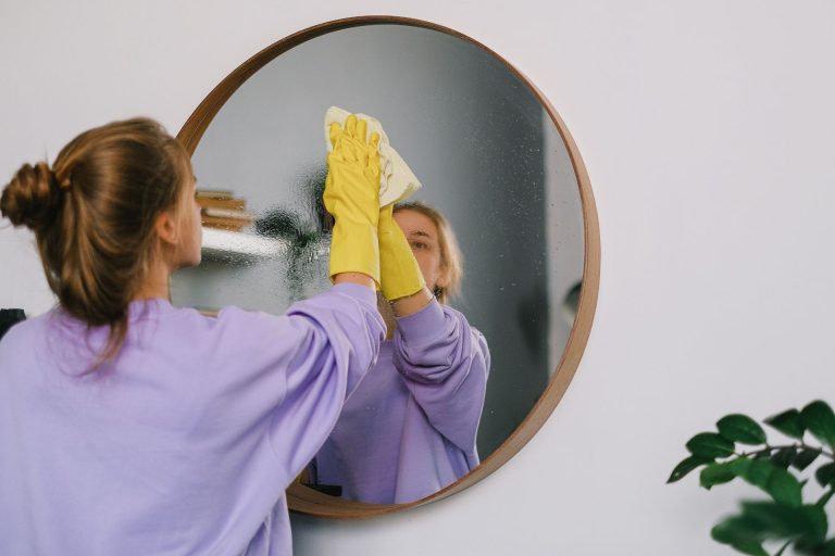 A woman cleaning a mirror