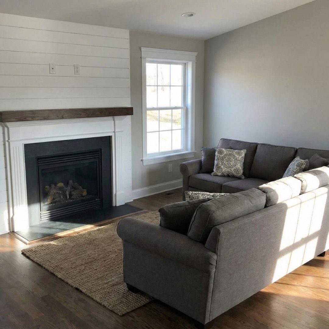 A beautifully restored and furnished living room with a fireplace and sectional sofa.